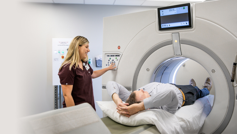 Female nurse controlling lung cancer machine of a patient getting checked.