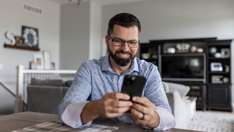Man holding smart phone smiling.