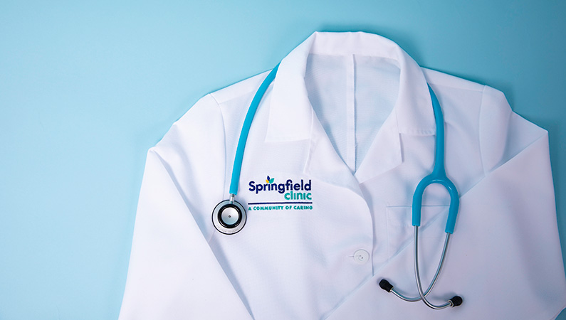 White medical coat with bright blue stethoscope on light blue background