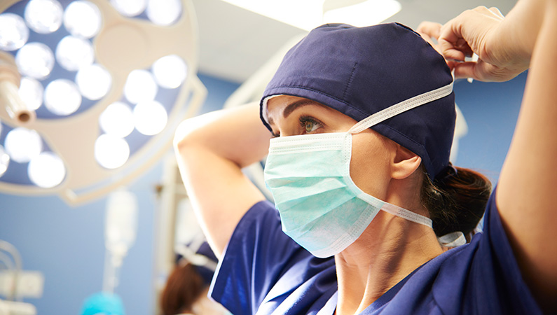 Female medical professional with mask in surgical setting
