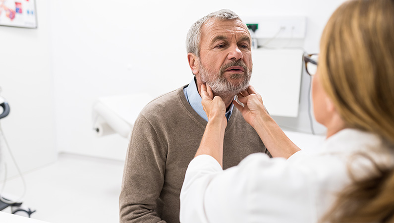 Patient getting throat checked by medical professional in medical office setting