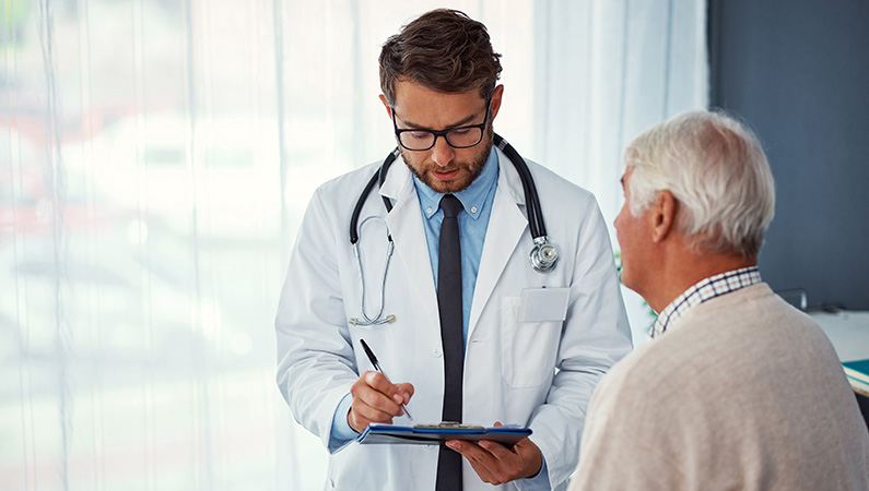 Elderly patient conversing with middle-aged male doctor