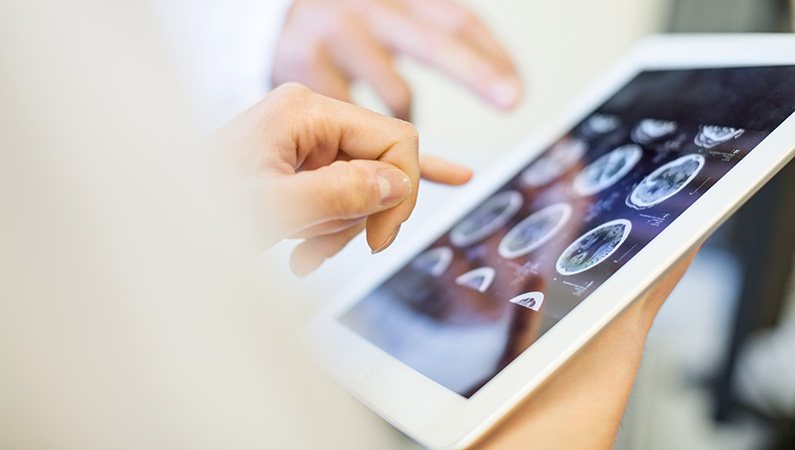 Fingers pointing to tablet with photos of x-ray displaying