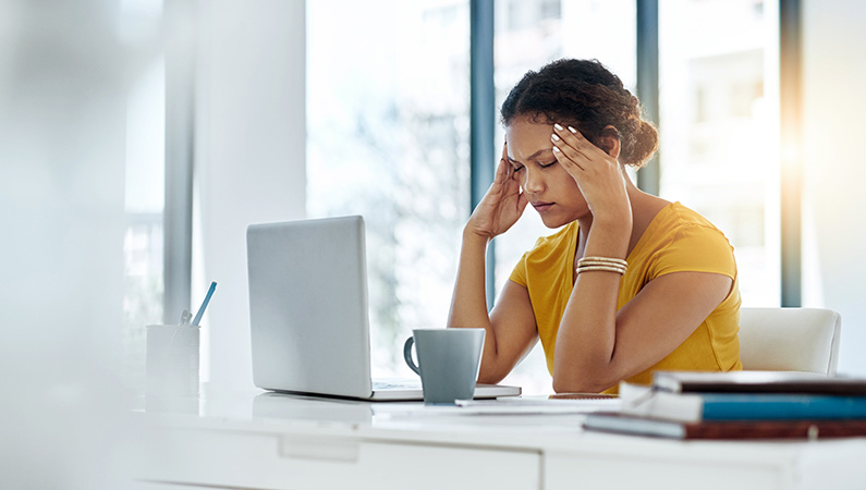 Middle-aged female in office setting with visible head pain