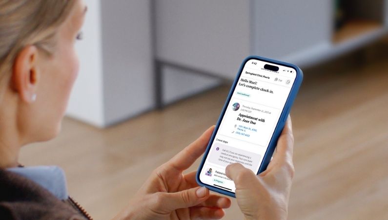 Female looking at iPhone with athenahealth enhanced self check-in homepage loaded on screen