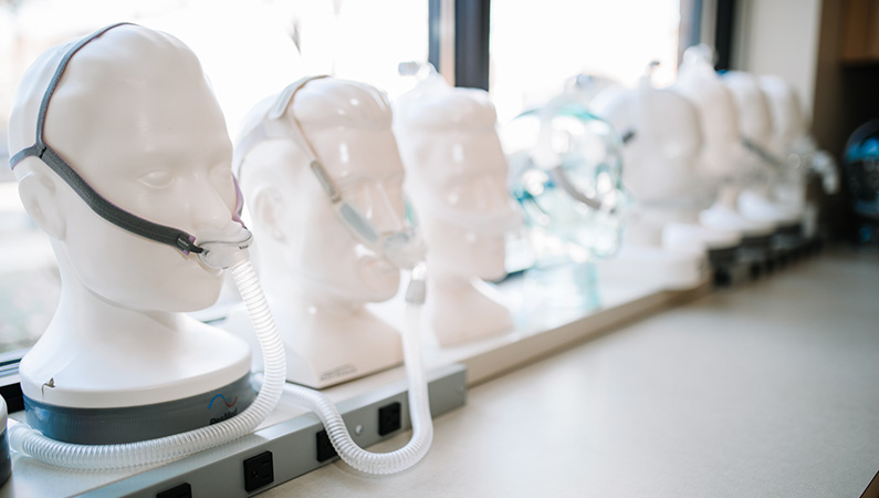 Mannequins lined up on windowsill modeling sleeping aid masks and gear