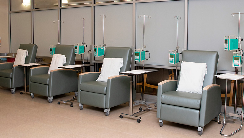 Empty chairs with pillows connected to infusion medical equipment