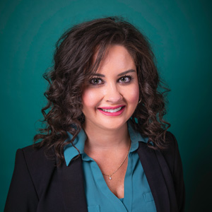 Professional headshot of female with dark curly hair