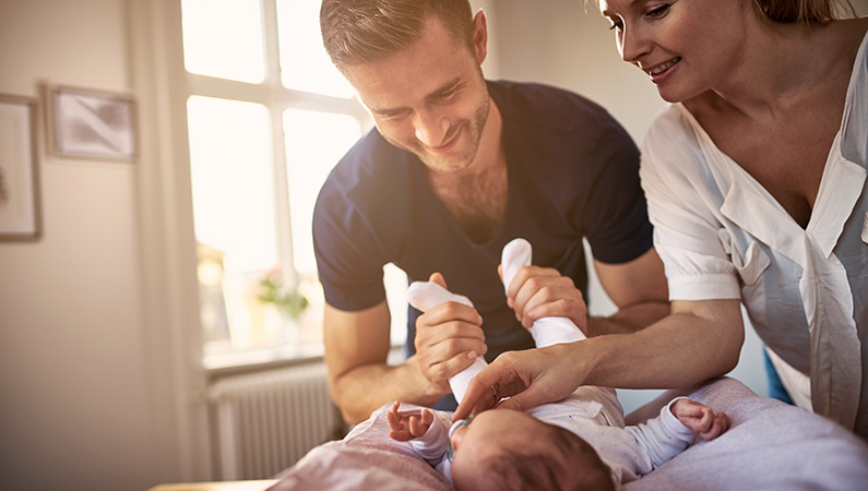Couple interacting with and entertaining newborn baby