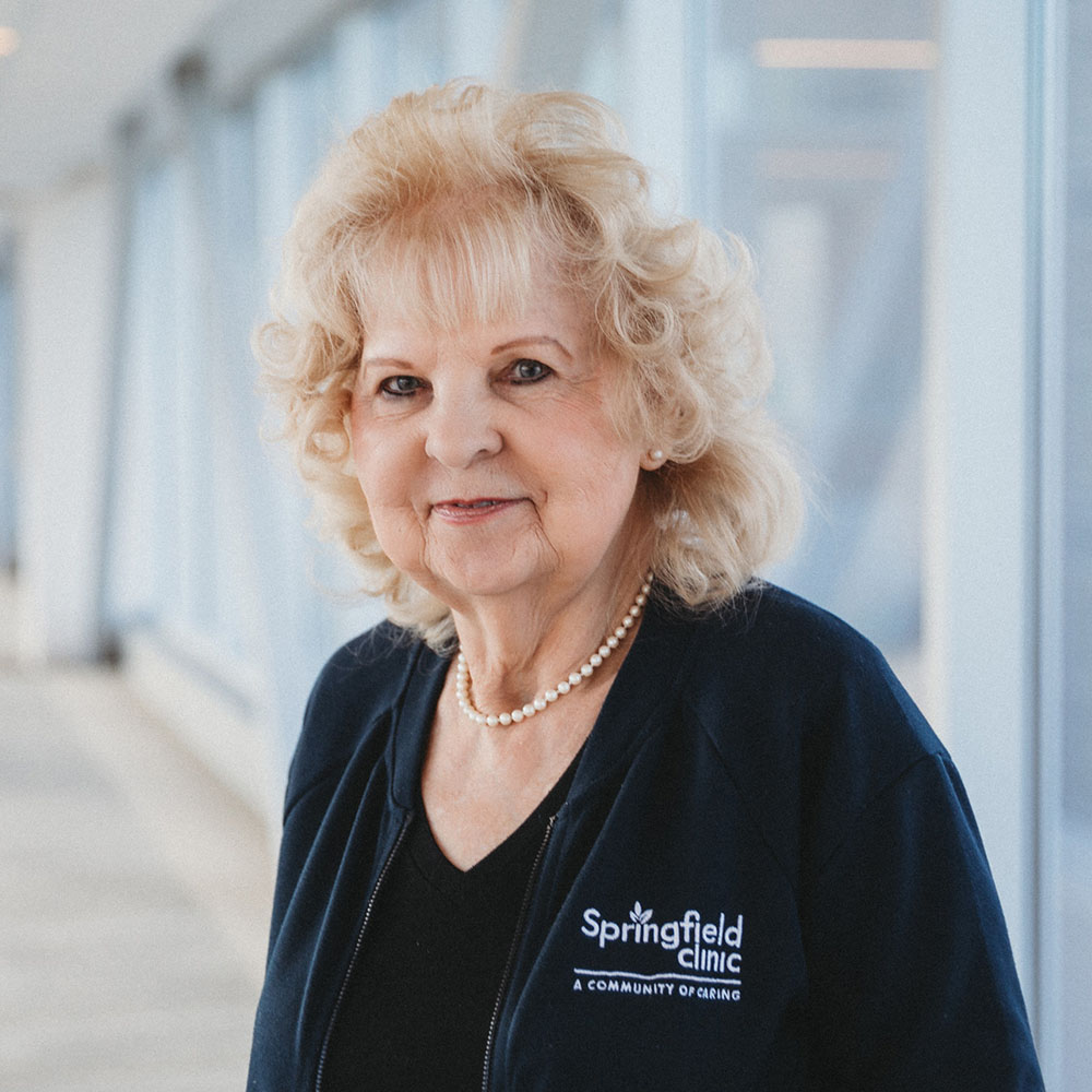 Female Springfield Clinic greeter, Barbara Davis, smiling outside.