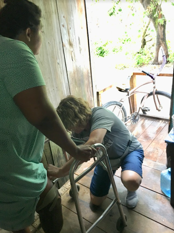 Female orthopedics doctor helping woman walk with the assistance of a walker