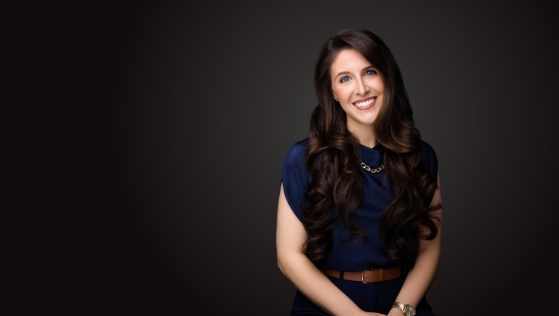 Female nurse injector smiling in professional headshot.