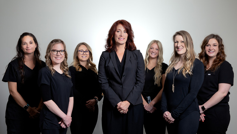Group photo of Springfield Clinic Chiropractic & Acupuncture team of seven women wearing all black.