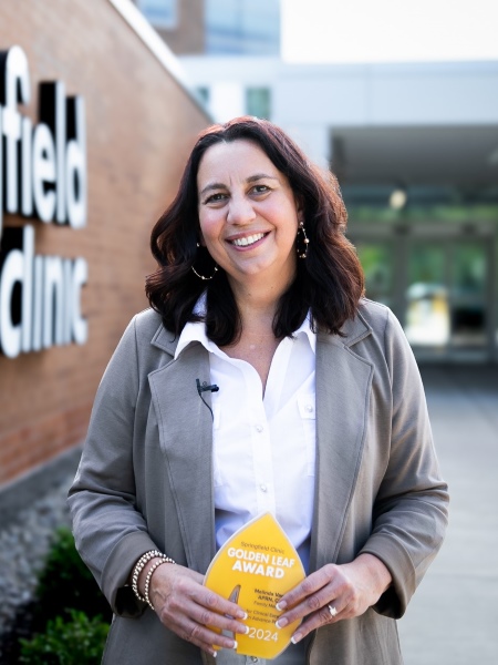 Mindy Vance, APRN, CNP, smiling holding Springfield Clinic 2024 Golden Leaf Award.