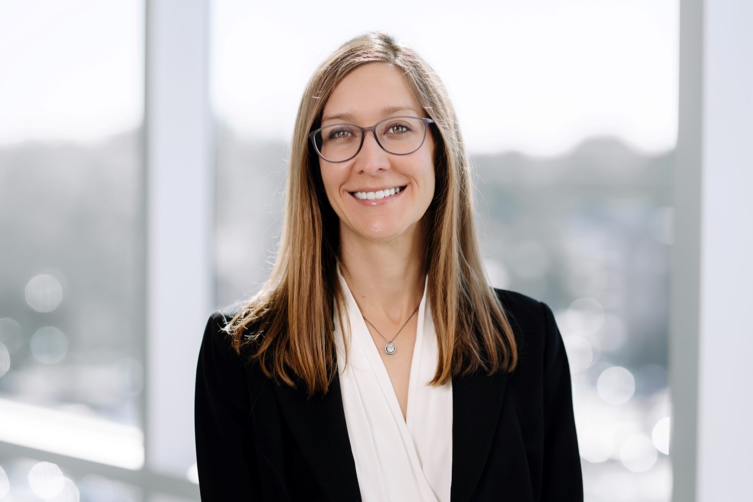 Abigail Cochran, MD, smiling in front of well lit hallway