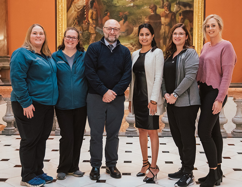 Dr. Dayoub smiling with four nurses and Illinois State Rep. Barbara Hernandez in the hallway of the Illinois House of Representatives.