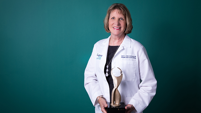 Female medical professional posing with prestigious award