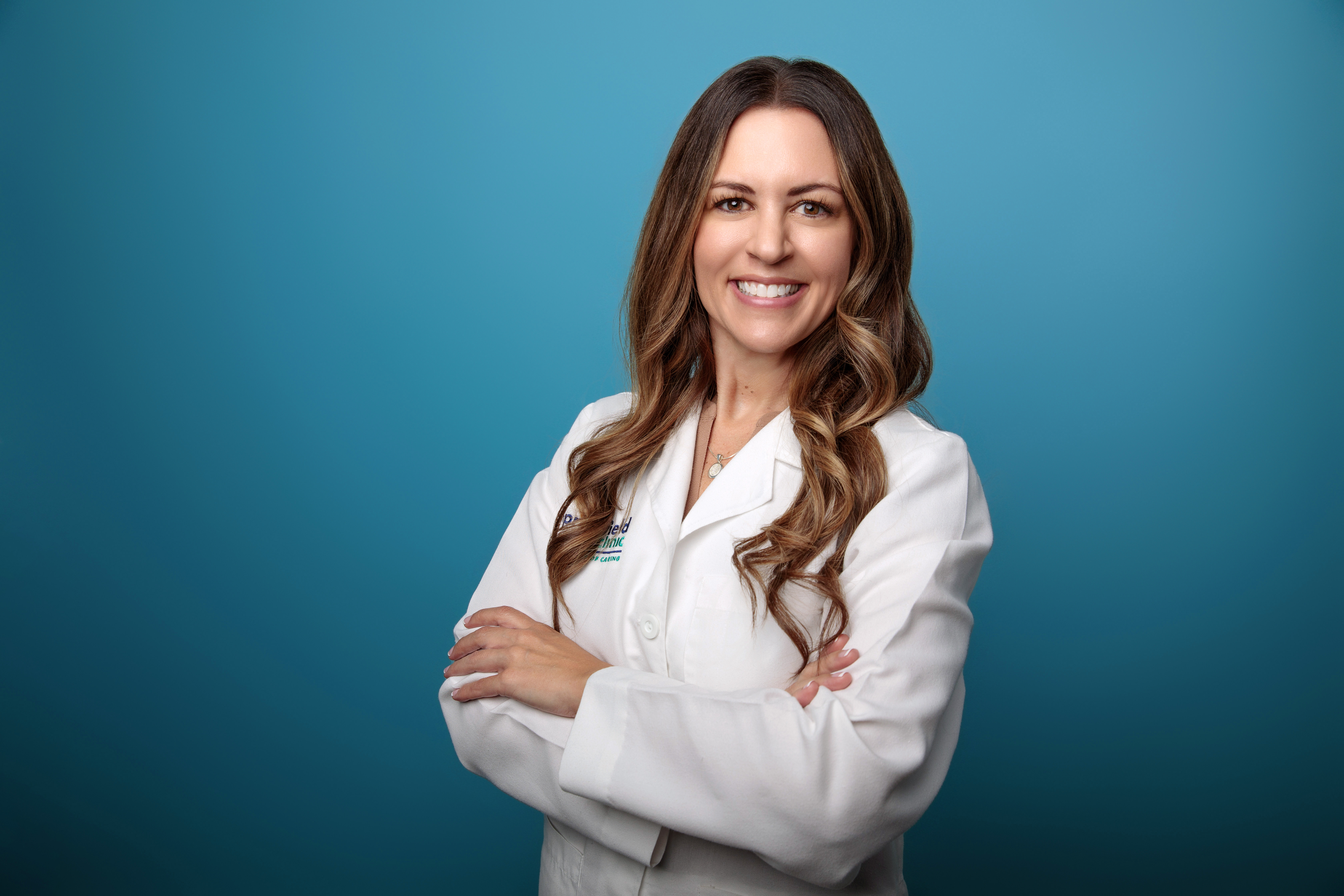 Female wearing white medical coat posing in front of blue background