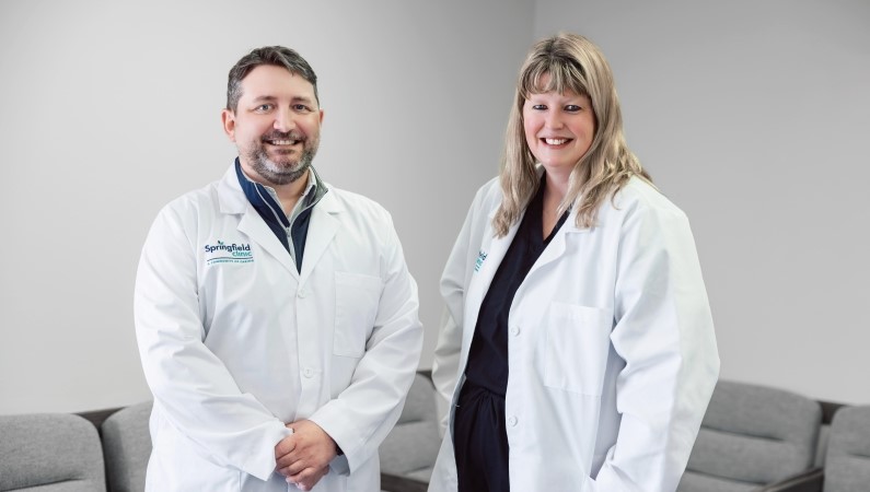 Pekin Podiatry providers smiling wearing white medical coats.