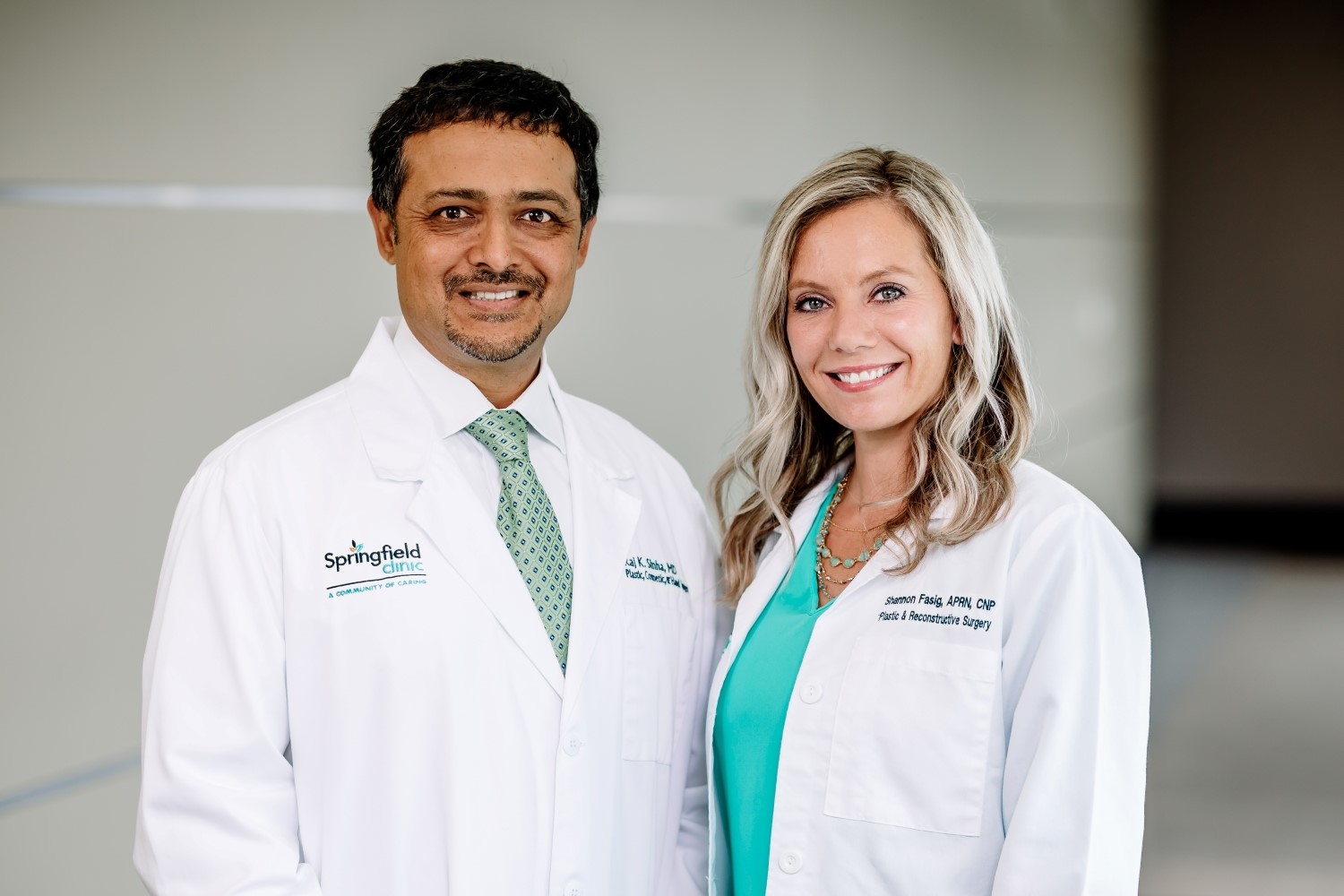 Dr. Sinha and Shannon Fasig smiling in medical hallway