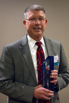 Dr. John Kwedar with Springfield Clinic Eye Institute smiling while holding 2024 Eveloff Award.