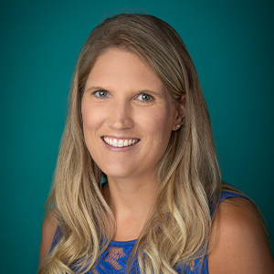 Female smiling with blue photo backdrop