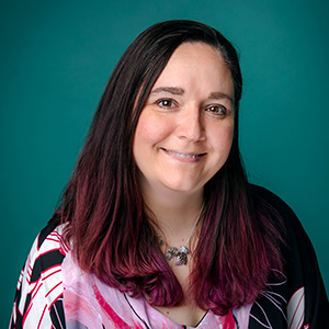 Female general surgery doctor smiling in professional headshot.