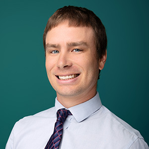Male pediatrician smiling in professional headshot.