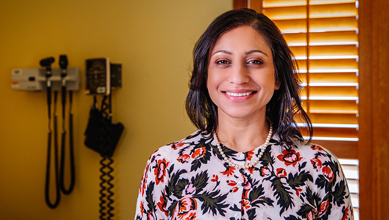 Woman smiling in yellow patient room.
