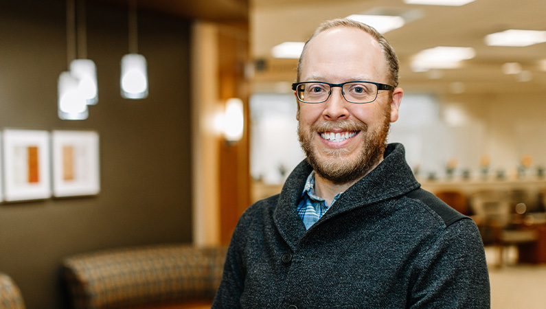 Family medicine doctor smiling in patient waiting room.