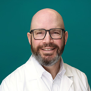 Orthopedic physician smiling in professional headshot.