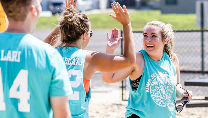 Two teammates smiling giving each other a high-five.