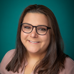 Female nurse practitioner smiling in professional headshot.