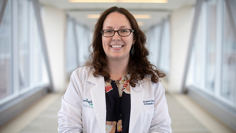 Woman smiling in a well lit walk way.