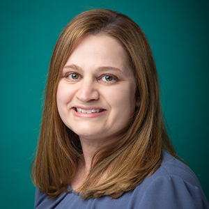 Female nurse practitioner smiling in professional headshot.