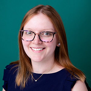 Female registered dietitian smiling in front of photo backdrop.