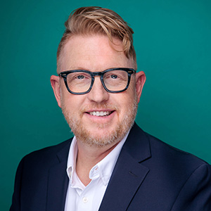 Male women's health doctor smiling in professional headshot.