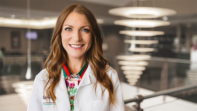 Woman smiling in a well lit lobby.