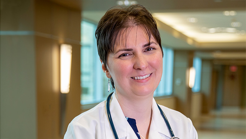 Woman smiling in a well lit lobby.