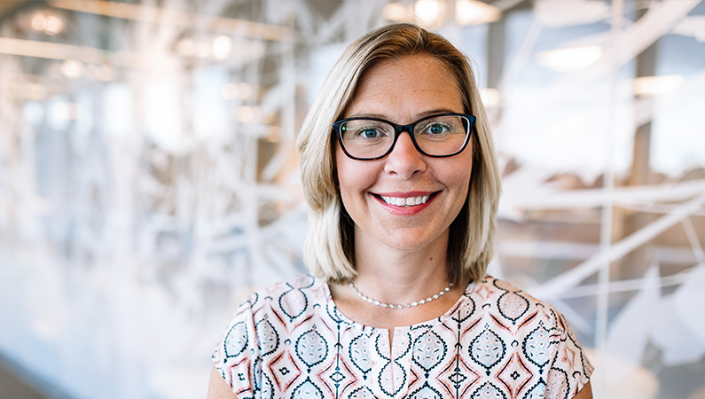 Woman smiling in a well lit hallway