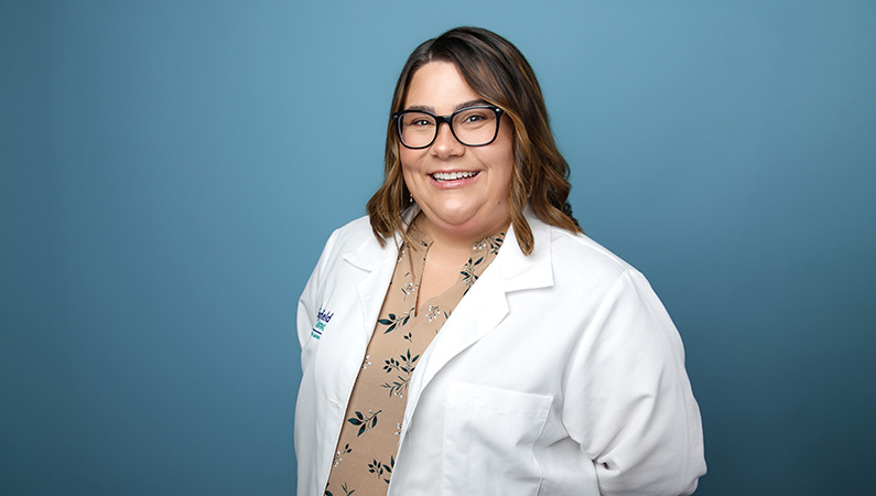 Female nurse practitioner smiling in professional headshot