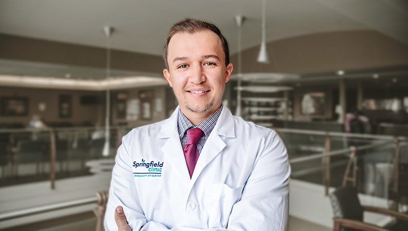 Man smiling in a well lit lobby.