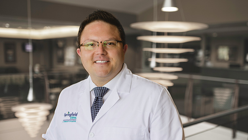 Man smiling in a well lit lobby.