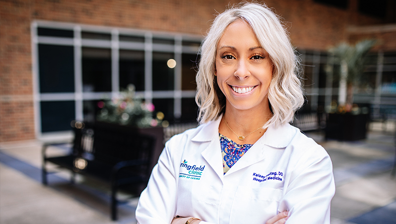 Woman smiling outside in front of the clinic.