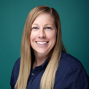 Female nurse practitioner smiling in professional headshot.