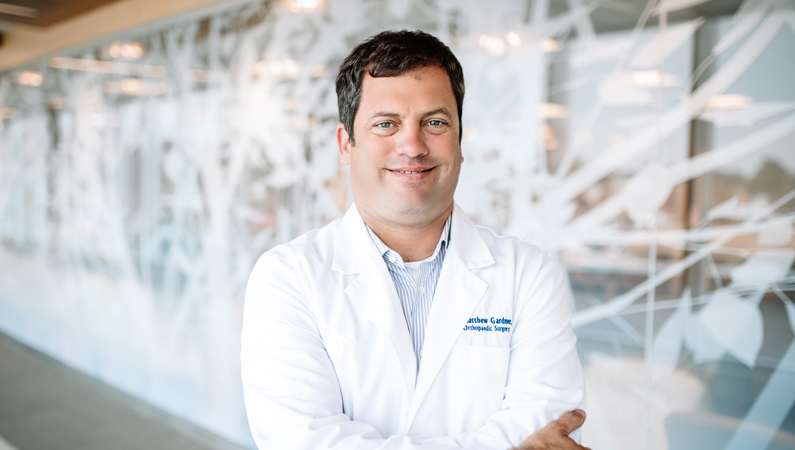 Man smiling in a well lit hallway.