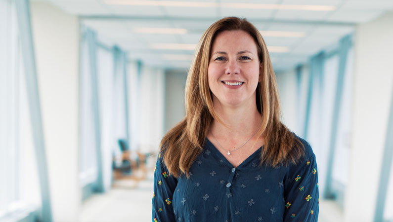 Female doctor smiling in a well lit hallway.
