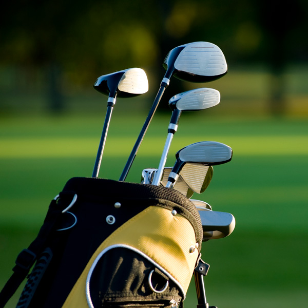 Set of golf clubs on a sunny golf course.