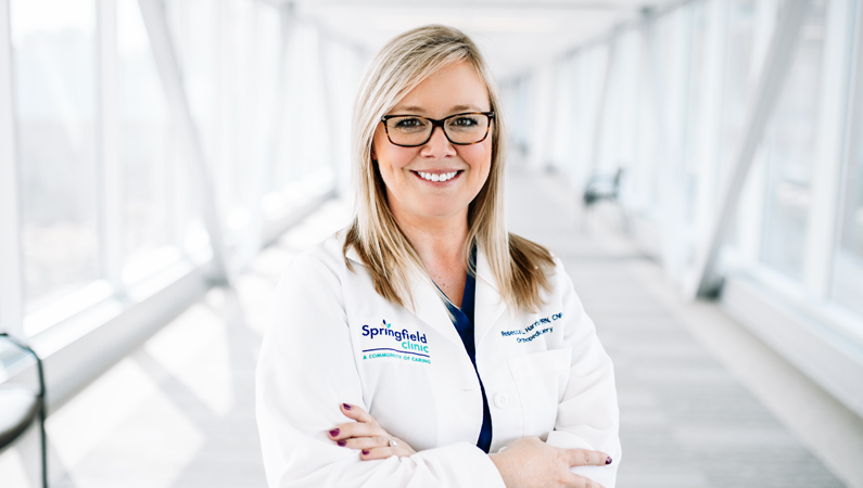 Woman smiling in a well lit walk way.