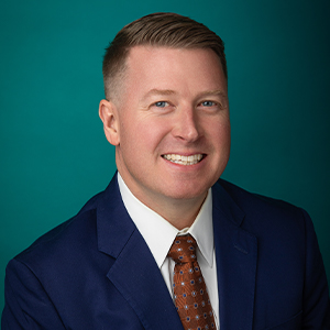 Male physician smiling in professional headshot.